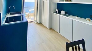 A modern kitchen with a built-in sink, white cabinets, and a view of the sea. - Apartment La Scogliera - Riomaggiore (Riomaggiore)