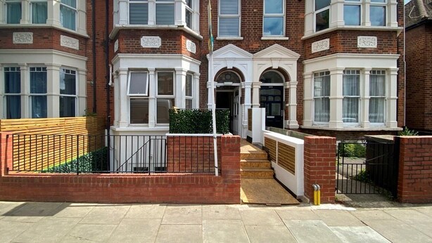 A two-story brick house with bay windows, a front entrance, and a small front garden. - Spacious and bright modern styling 3 bed flat (LONDON)