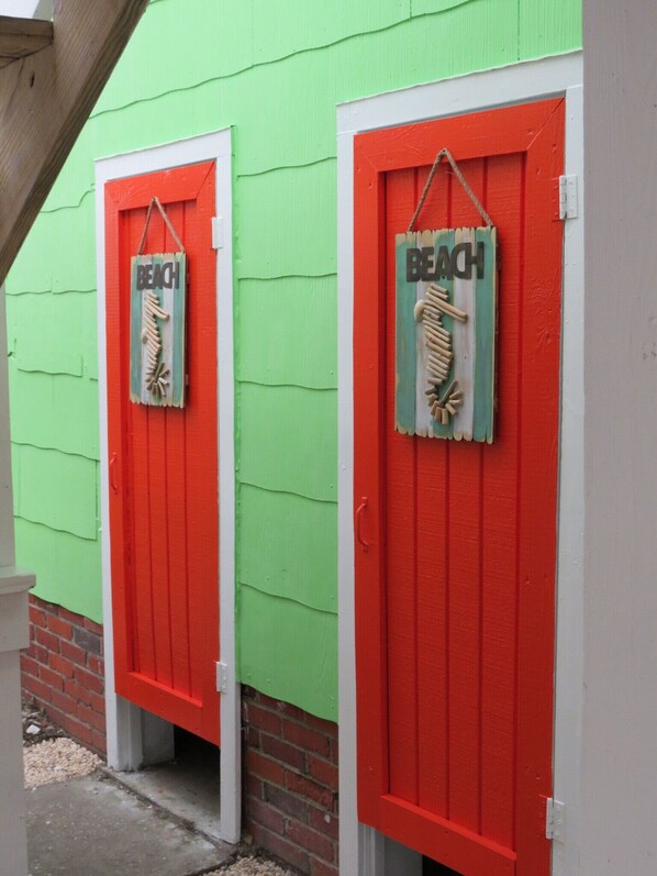 Two red doors with 'BEACH' signs and wooden sculptures of beach elements.