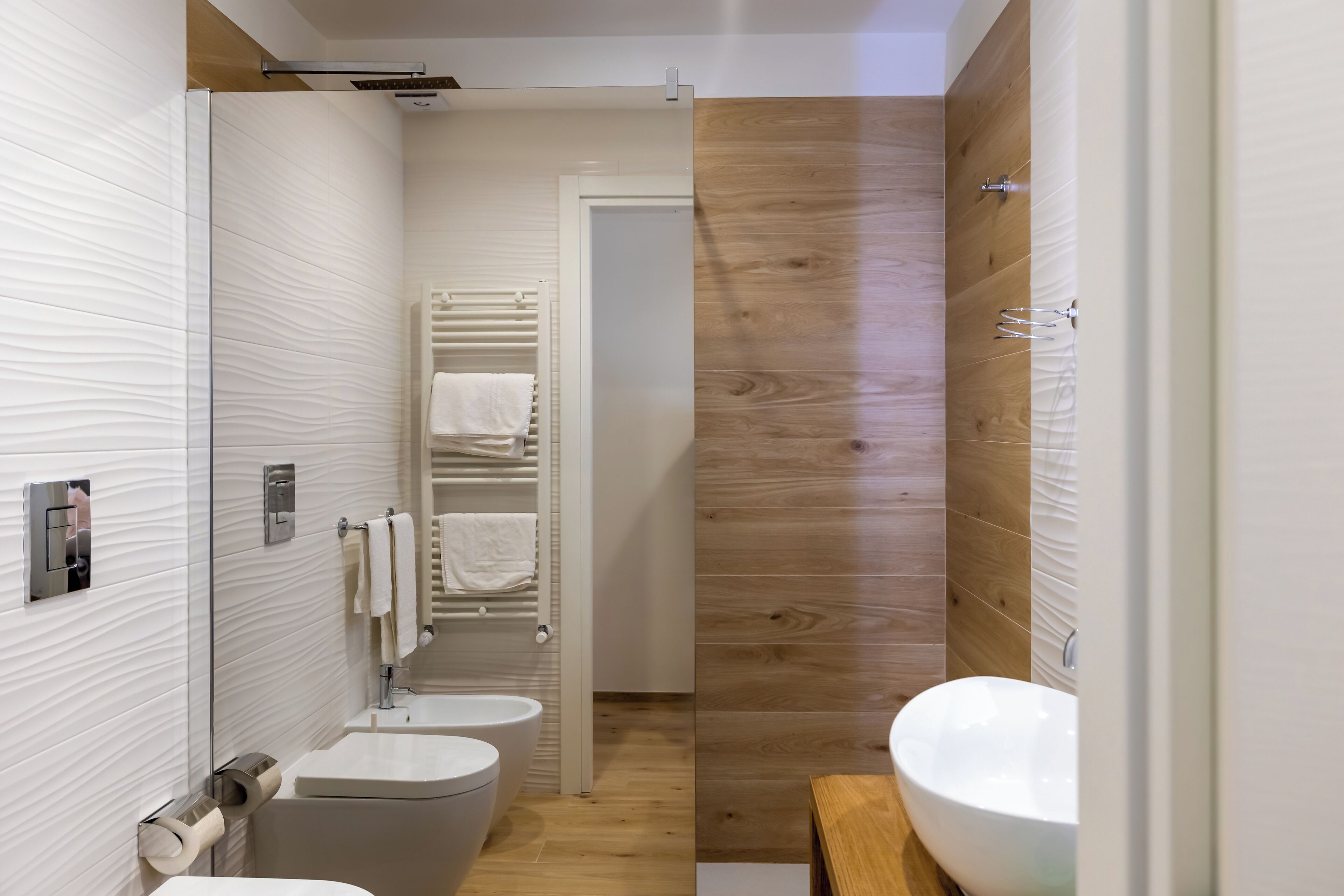 A modern bathroom with a toilet, sink, and shower area.