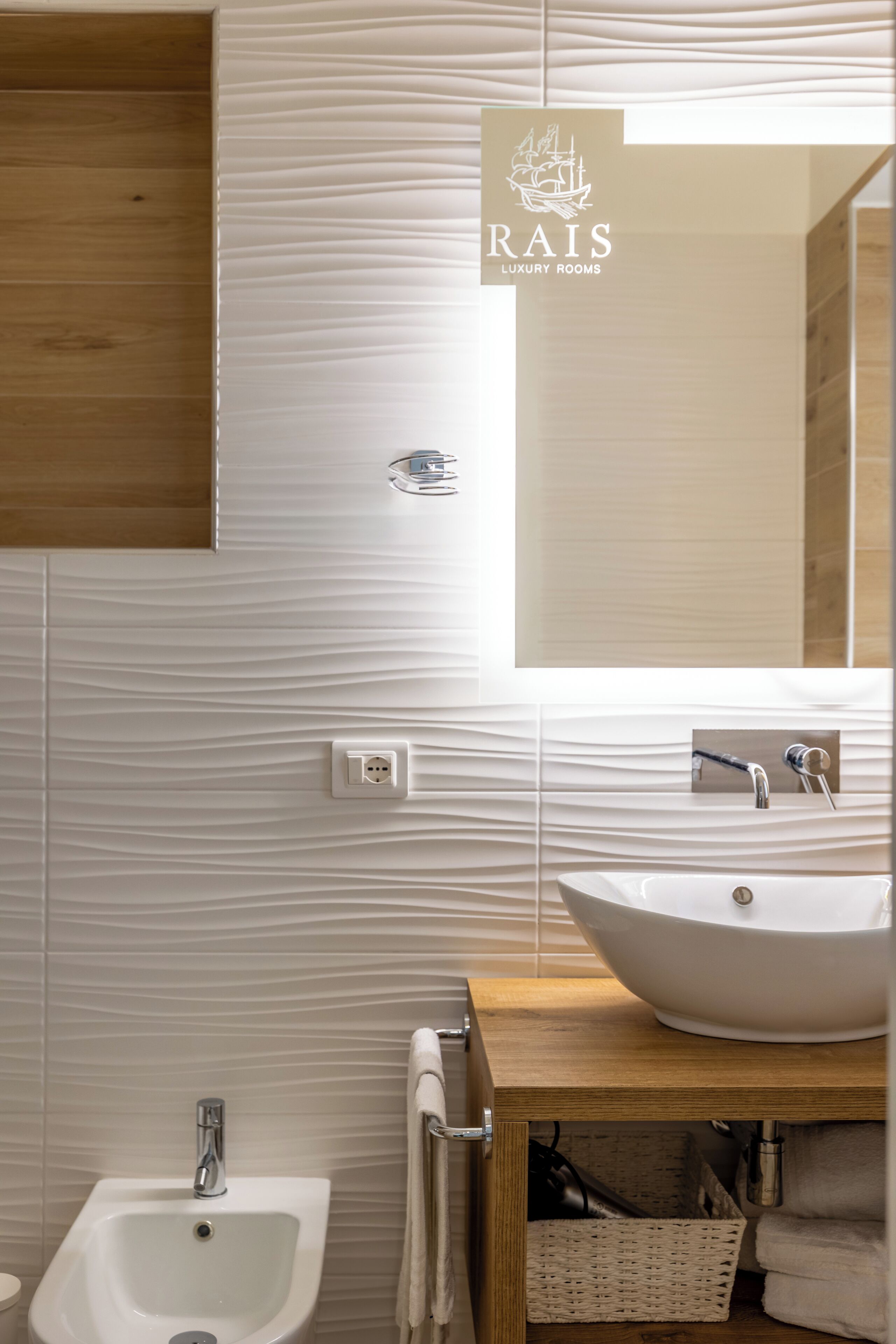 A modern bathroom with a large mirror, a vessel sink, and a bidet.