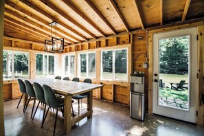 Enjoy meals at the dining table surrounded by windows offering a view of the outdoors.