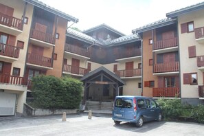 A multi-story building with balconies and a car parked in front. - 200m from shops, 2nd floor, balcony, tv, ski locker, 23m², Valloire (Valloire)