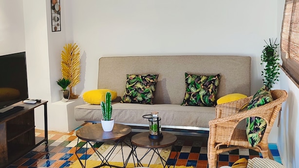 A living room with a sofa, coffee table, ottoman, and wicker chair. - Cozy, bright, terrace-solarium, rustic living room. Very close to Madrid... (Villarejo de Salvanés)