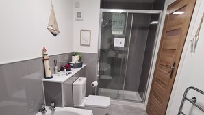 A modern bathroom with a bathtub, toilet, and shower area. - HEART OF INVERNESS MODERN APARTMENT (Inverness)