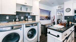 A modern kitchen with built-in appliances, a washing machine, and a dining area with a view of the city. - 3-BR house walk to beach, shopping, bars, NYC train. 6-beach passes & 4-bikes. (Asbury Park)