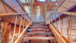 Una escalera de madera con barandales de metal que conduce a un nivel superior.