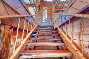 A wooden staircase with metal railings, leading to an upper level.