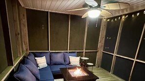 A cozy outdoor seating area with a sofa, a small table, and a fire pit. - Premier Waterfront Location! Big, clear water views! Fire table! (Dadeville)