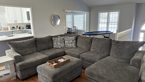 A modern living room with a sectional sofa, a wooden coffee table, and a pool table. - Chandler Retreat - Lakehouse (Acworth)
