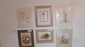 Un mur orné de six œuvres d’art encadrées, représentant différents sujets.