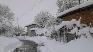 Un étroit sentier enneigé entre les bâtiments.