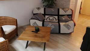 A cozy living room with a wooden coffee table, wicker chairs, and a patterned sofa.