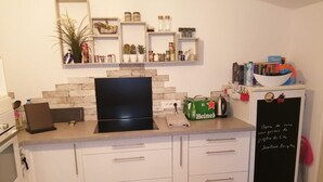 A kitchen with white cabinets, a black stove, and a chalkboard with writing.