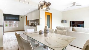 Una cucina moderna con zona pranzo, divano e televisione.