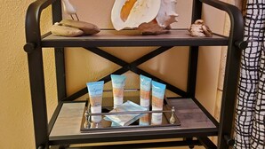 A chair with a tray holding toiletries and decorative shells. - Private Cozy Studio walking distance to beaches, shops, restaurants and bars (Kihei)