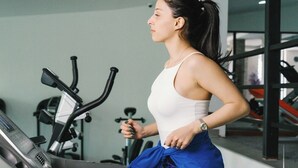 A woman running on a treadmill in a gym with exercise equipment in the background. - Bakuriani Crystal Loft 406 (Borjomi)