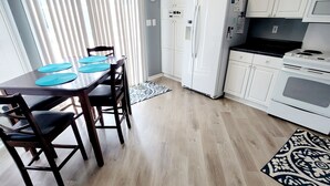 Una cocina moderna con armarios blancos, encimera negra y horno empotrado.