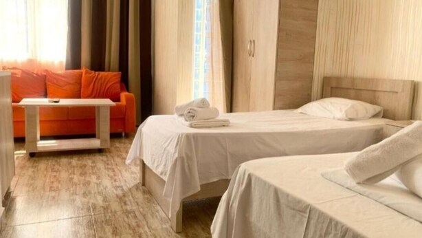 A hotel room with two beds, a sofa, and a table. - Batumi Hall (Batumi)