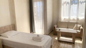 A hotel room with a bed, a sofa, and a small table. - Batumi Hall (Batumi)