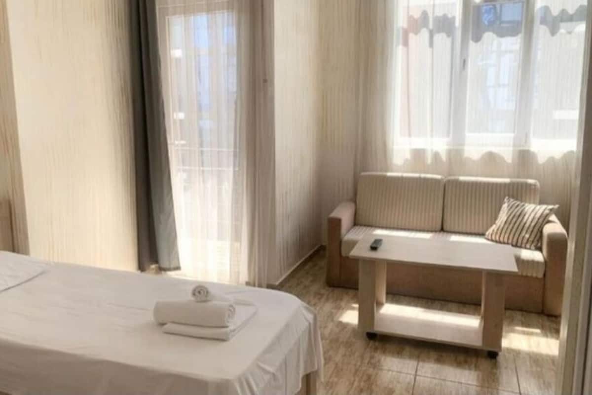 Una habitación de hotel con una cama, un sofá y una pequeña mesa.