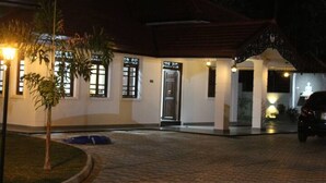 A building with a tiled entrance, a door, and a small garden with a palm tree. - Heaven villa (mirissa)
