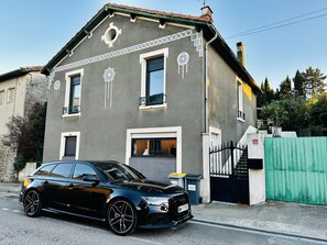 Une maison à deux étages avec une voiture garée devant.