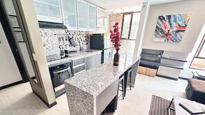 Eine moderne Küche mit Granit Arbeitsplatten, Edelstahlgeräten und einer zentralen Kochinsel.