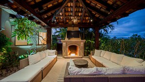 An outdoor lounge area with wicker furniture, a fireplace, and a star-shaped light fixture. - Breathtaking Views, Private Pool/Spa adjacent to One&Only Palmilla!! (San José del Cabo)