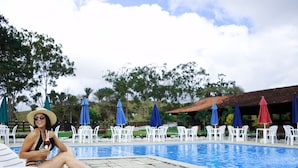 A pool area with lounge chairs and umbrellas. - CONDOMÍNIO FAZENDA TRÊS TESOUROS (Bonito)