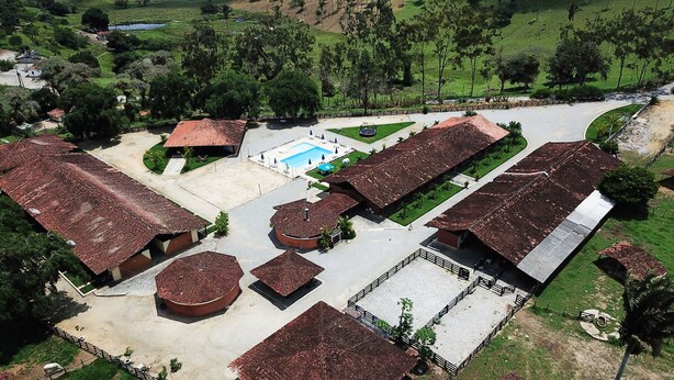 An aerial view of a resort with multiple buildings, a swimming pool, and surrounding greenery. - CONDOMÍNIO FAZENDA TRÊS TESOUROS (Bonito)