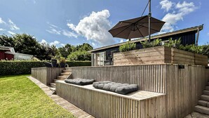 A modern outdoor seating area with built-in benches and a wooden deck. - Lovely home in Haderslev with WiFi (Haderslev)