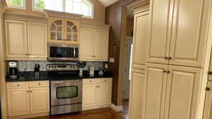 A kitchen with a large island, stainless steel appliances, and cream-colored cabinetry. - Water and Beach Front Property 4 season on Ottawa River with Private Boat Launch (Deep River)