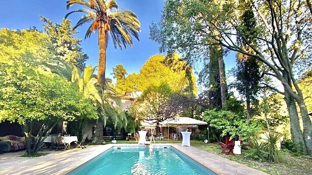 Una piscina envoltada de vegetació exuberant i arbres.