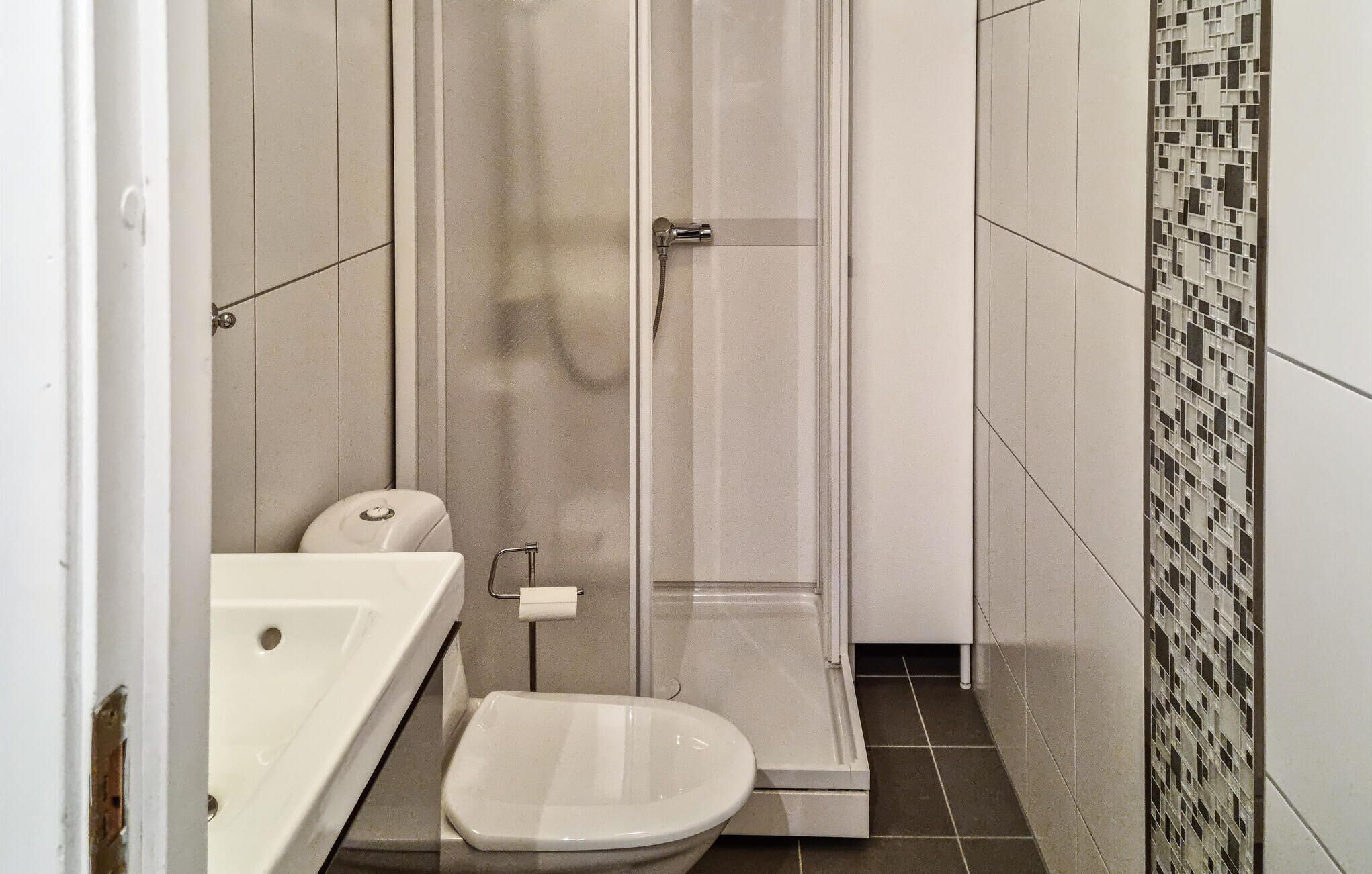 Un baño pequeño con inodoro, ducha y lavabo.