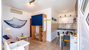 Een compact woongedeelte met een kitchenette, een eethoek en een kinderspeelruimte.