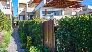 A residential area with modern houses, a gravel path, and a wooden gate. - Nice apartment in Castglione Della P. (Castglione Della P.)