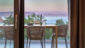 A dining area with a table and chairs, a bottle of wine, and two glasses on the table. - Amazing home in Labin (Labin)