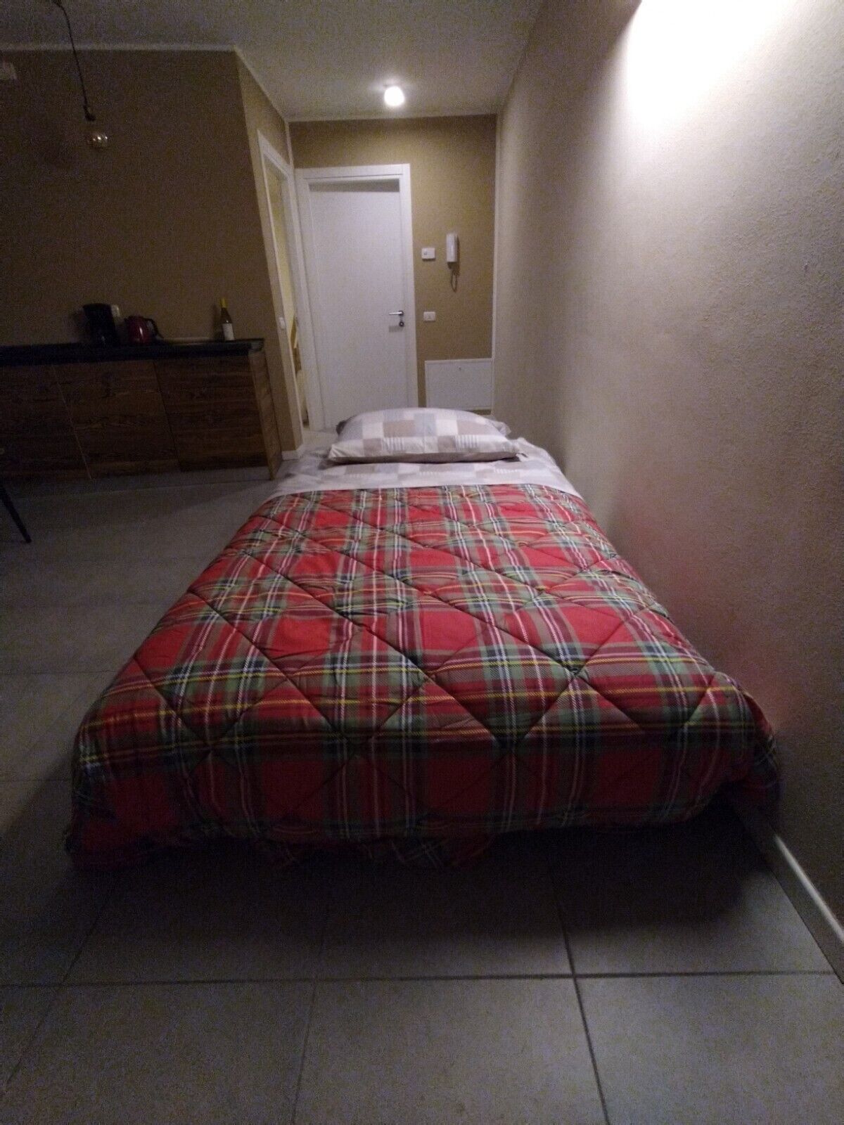 A bedroom with a bed, a dresser, and a door.