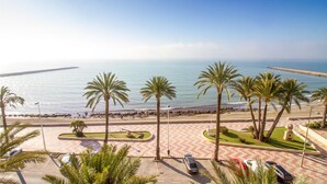 A beachfront parking area with palm trees, a clear view of the sea, and a paved walkway leading to the beach. - Awesome apartment in Santa Pola with WiFi (Santa Pola)
