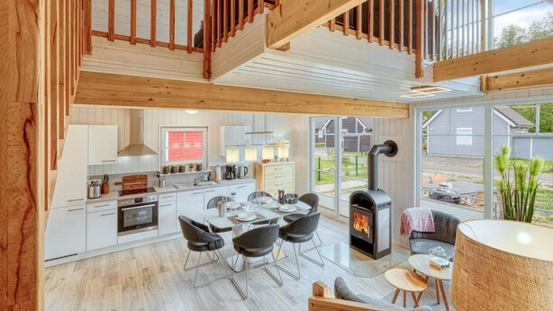 A spacious kitchen with modern appliances, a dining area with a large table and chairs, and a cozy living area with a fireplace. - Awesome home in Zerpenschleuse with sauna (Zerpenschleuse)