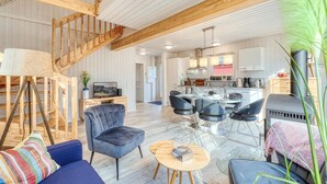 A spacious living area with a high ceiling, wooden beams, a staircase, a dining area with modern chairs, and a kitchen with white cabinets. - Awesome home in Zerpenschleuse with sauna (Zerpenschleuse)