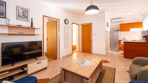 A modern apartment with a TV, wooden furniture, a kitchen, and a dining area. - Nice apartment in Krusevo with house sea view (Krusevo)