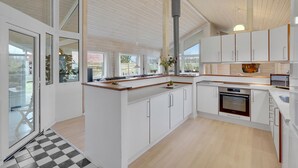 Una cocina moderna con armarios blancos, encimera de madera y una isla grande.
