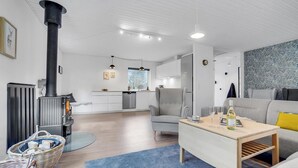 Ett modernt vardagsrum med en soffa, ett soffbord och en öppen spis.