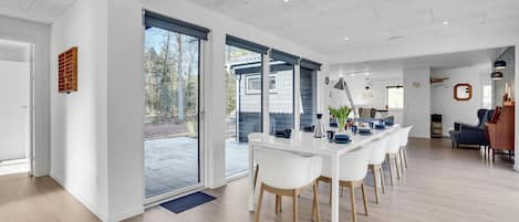 A modern kitchen with white cabinetry, a large island, and a view of the outdoors.