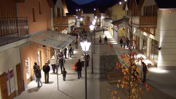 A pedestrian area with buildings, a covered walkway, and a street lamp.