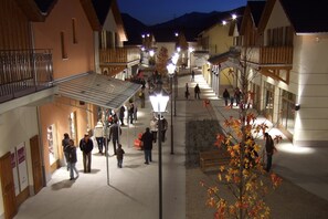 Uma área para pedestres com edifícios, uma galeria coberta e um poste de iluminação.