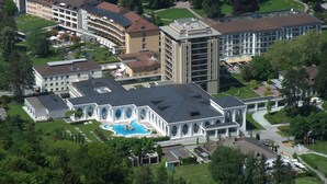 An aerial view of a hotel complex with multiple buildings, a swimming pool, and surrounding greenery. - Grand Maisonette-Attica, Jenins, Top of Heidiland (Jenins)