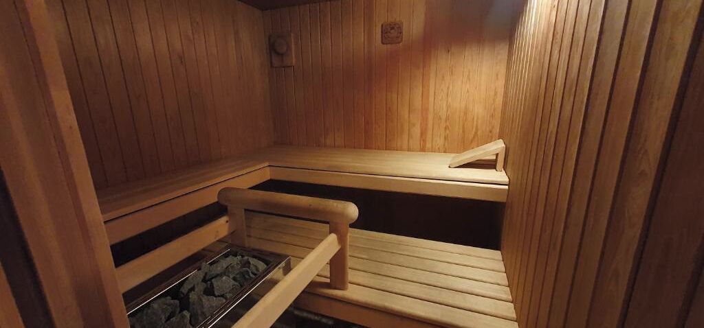 A sauna with wooden benches and a stone floor.
